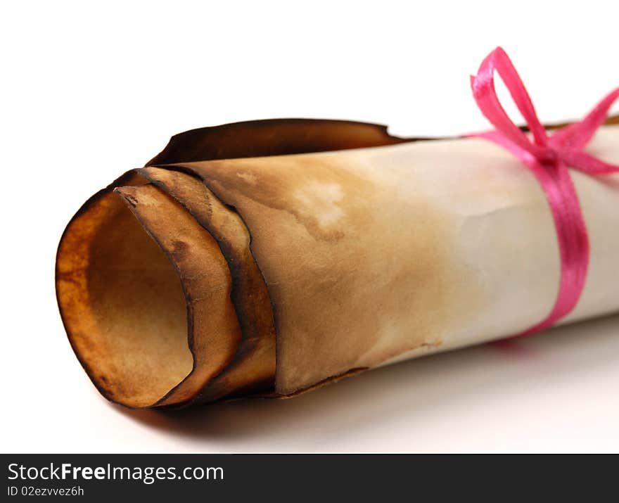 Close-up of a roll of yellowish burnt vintage parchment tied with a red ribbon Isolated on white background. Close-up of a roll of yellowish burnt vintage parchment tied with a red ribbon Isolated on white background