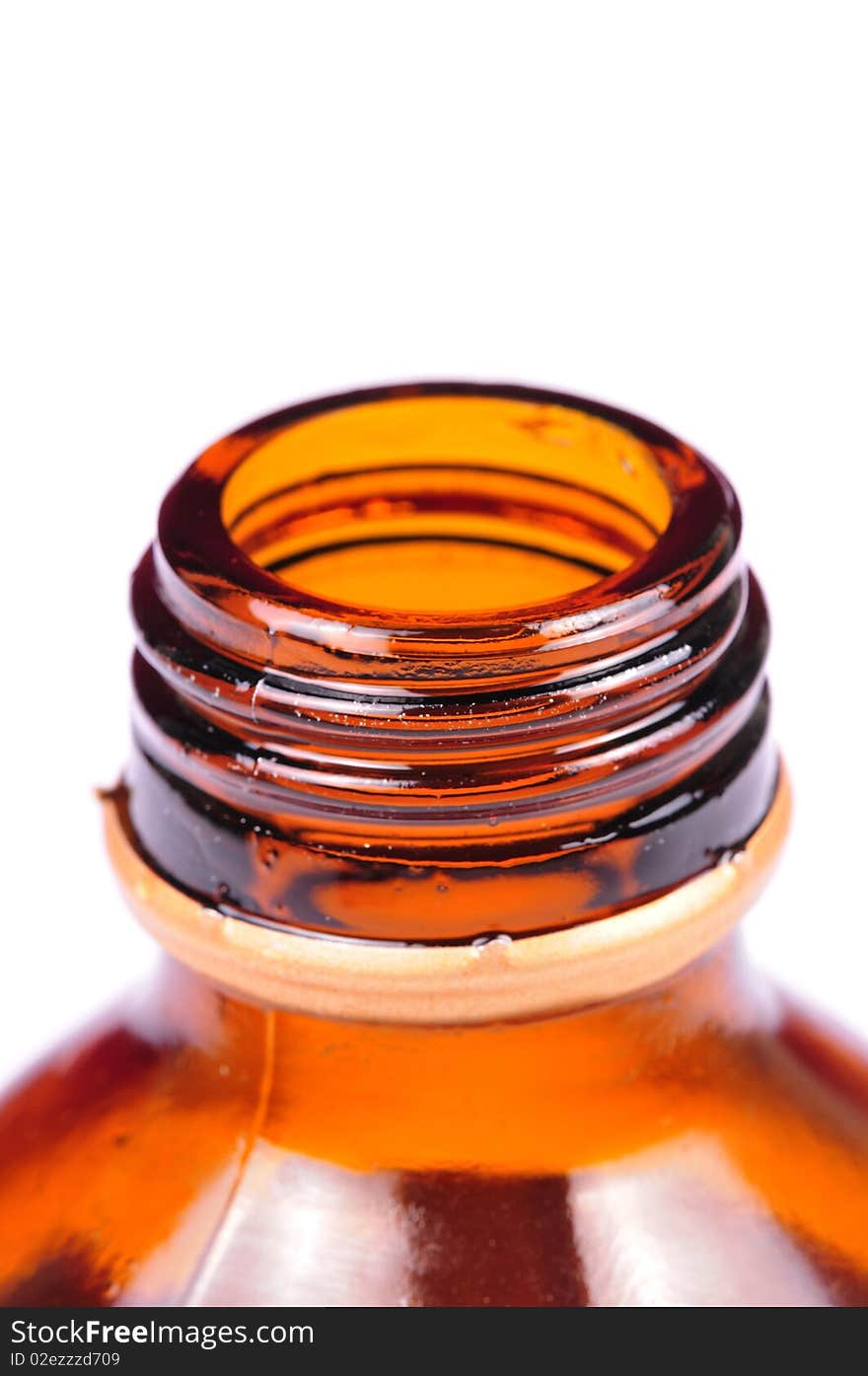 Macro shot of medicine bottle mouth over white background.