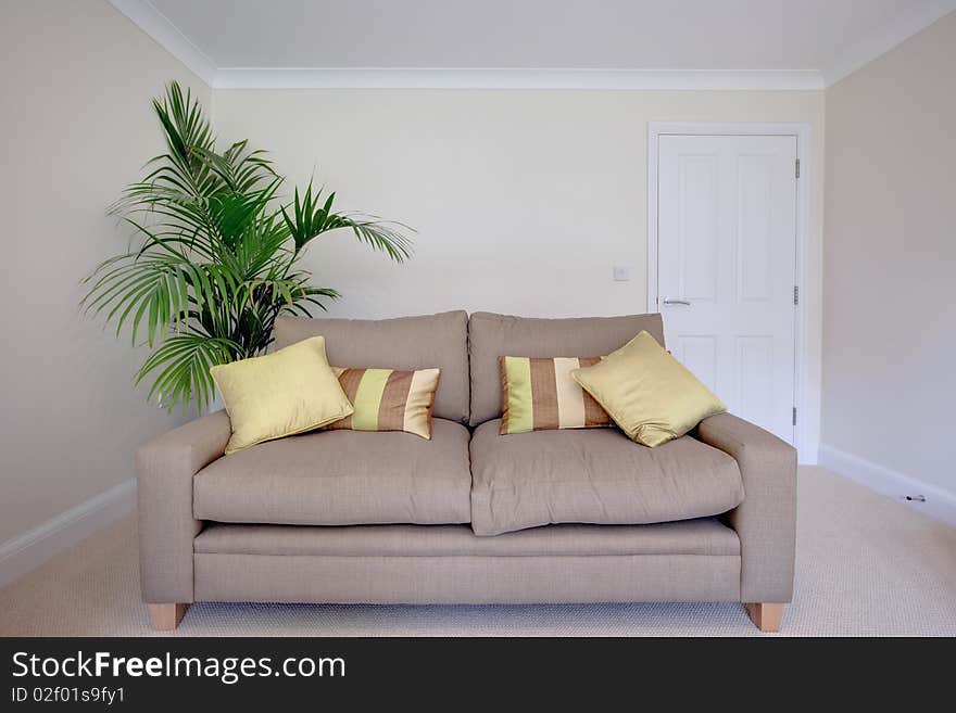 Modern chair within sparsely furnished room with brightly colored scatter cushions. Modern chair within sparsely furnished room with brightly colored scatter cushions