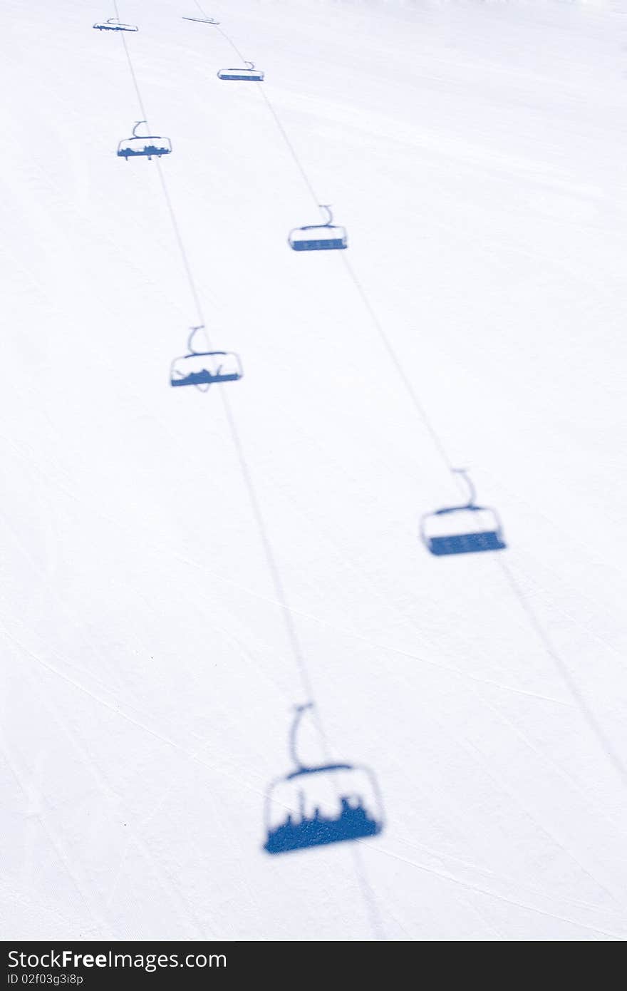 Blue shadows of chairlift on the snow. Blue shadows of chairlift on the snow