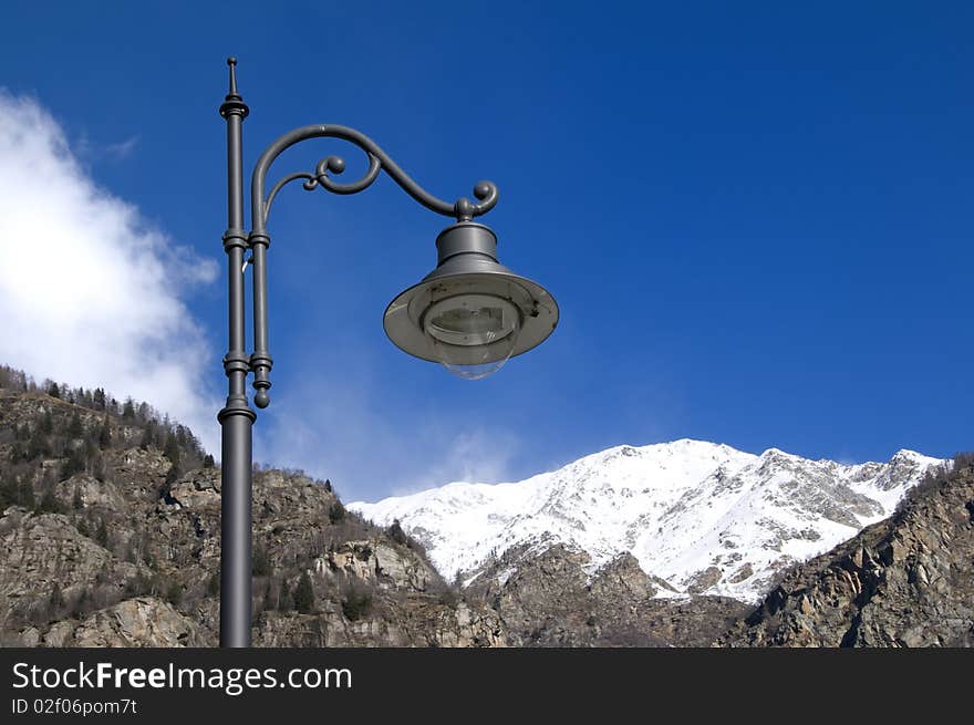 Picture of an old lamp with mountans in foreground. Picture of an old lamp with mountans in foreground