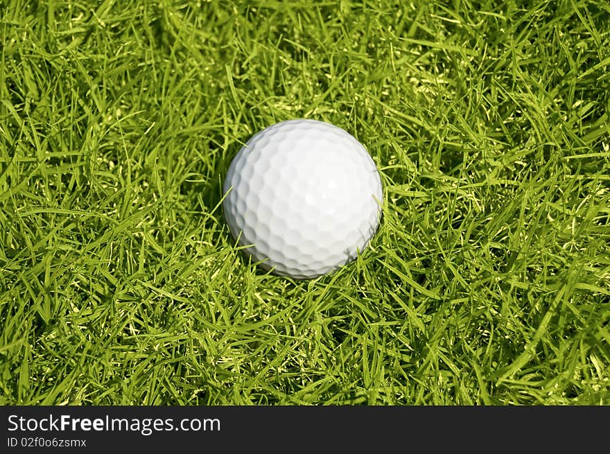 Golfing. A ball on the green grass background