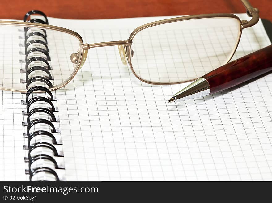 Notepad With Eyeglasses And Pen