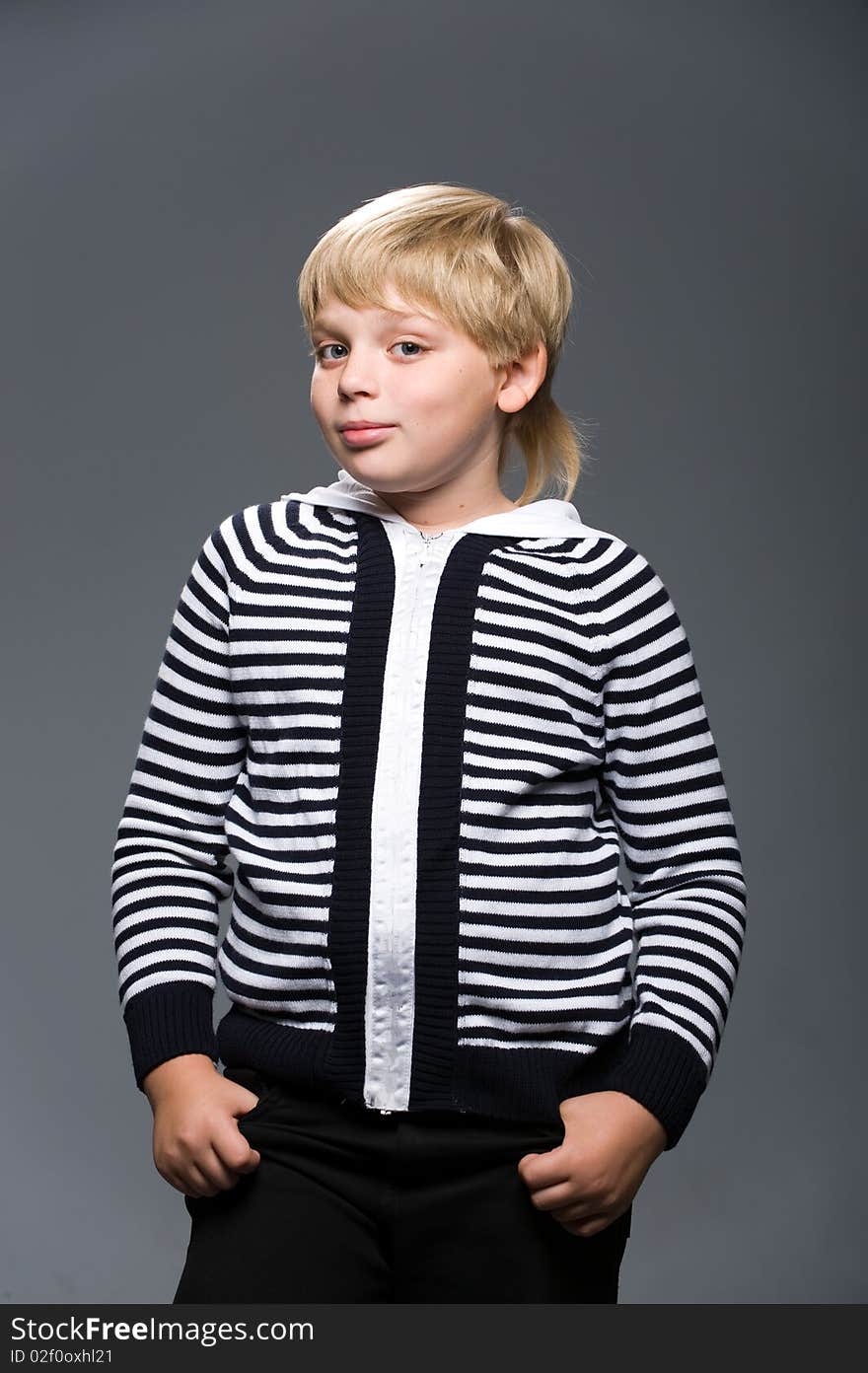 Young blond man in a striped sweater with a gray background. Young blond man in a striped sweater with a gray background