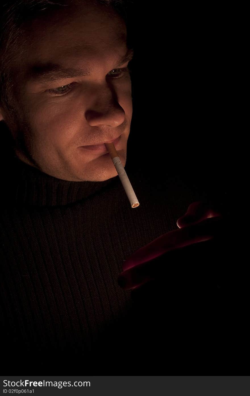 Man lighting up a cigarette at night, low light