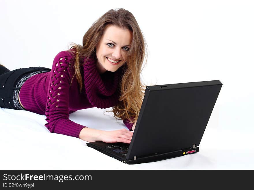 Lying and smiling attractive woman with a laptop