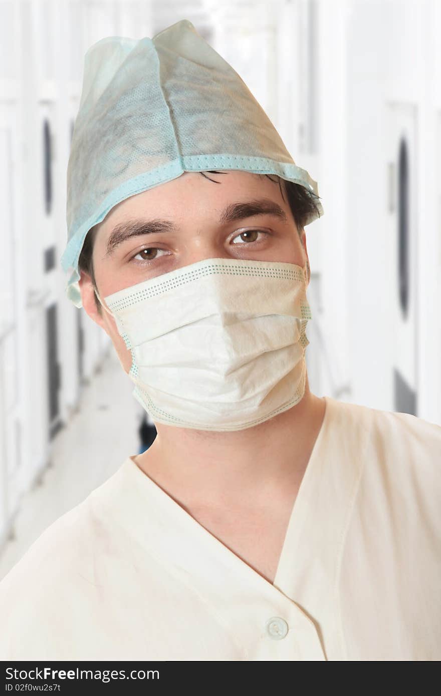 A portrait of a surgeon while an operation is being conducted in the background