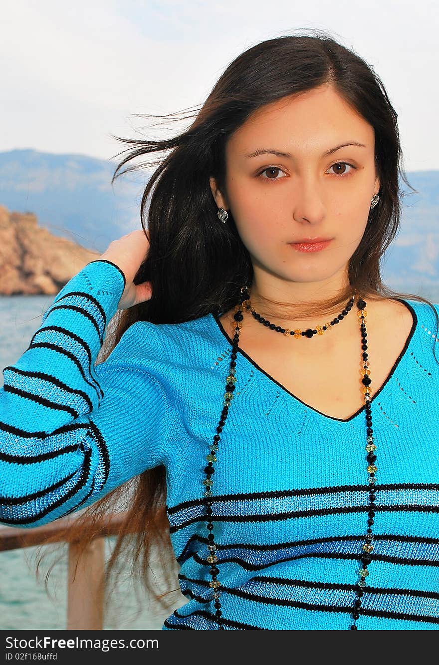 The girl on the nature in a blue sweater