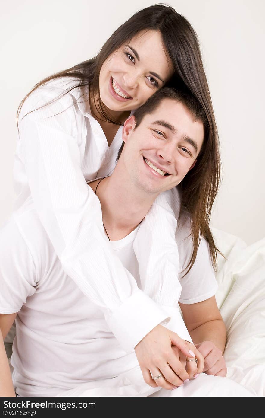 A young couple hugging in bed