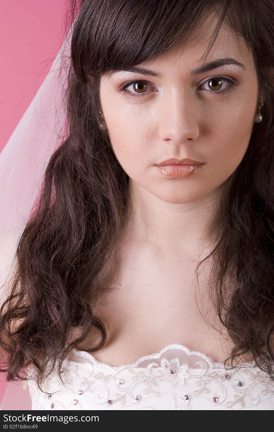 Studio portrait of a happy bride on a pink background