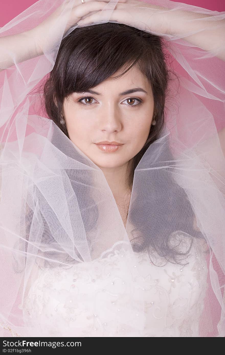 Studio portrait of a happy bride on a pink background