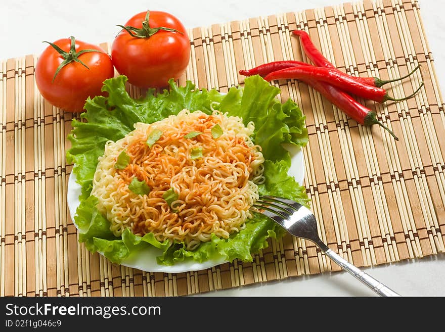 Dish of noodles on lettuce leaf