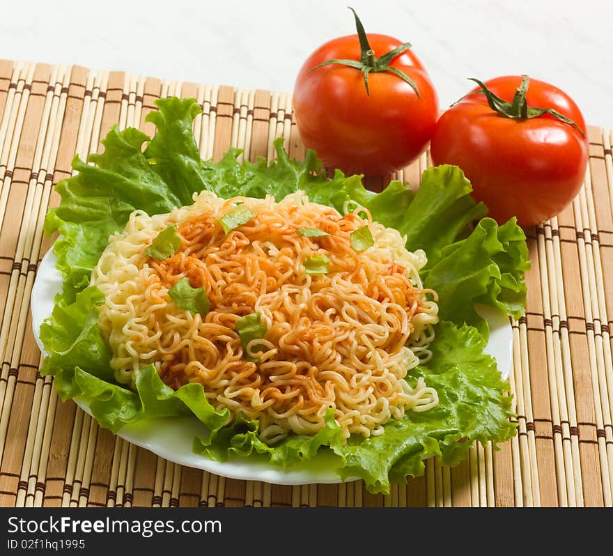 Dish of noodles on lettuce leaf