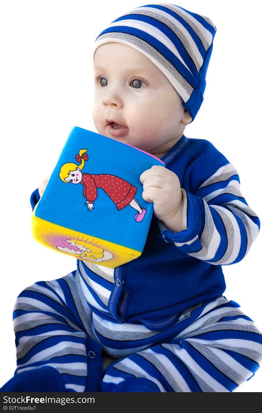 The baby of 6-7 months in a dark blue suit sits with a cube in hands