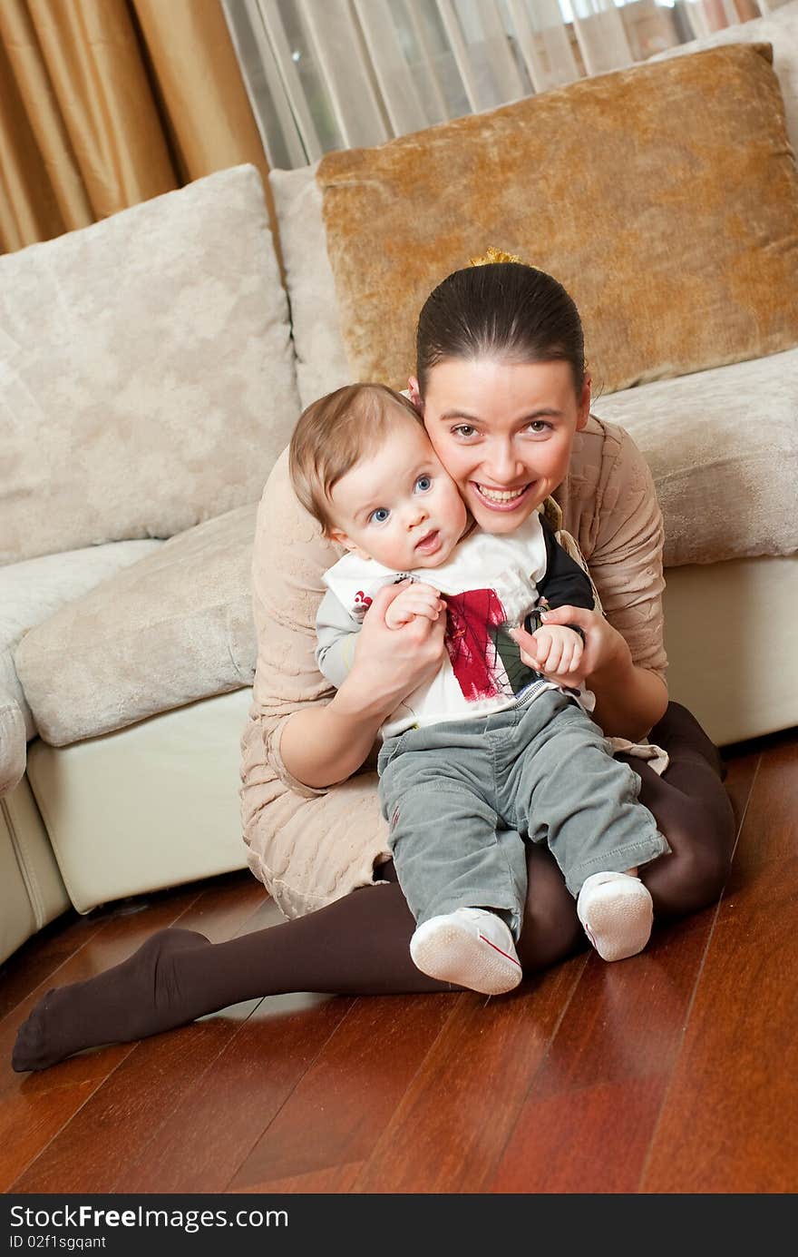 Happy young beautiful mother with her little son in home interior. Happy young beautiful mother with her little son in home interior