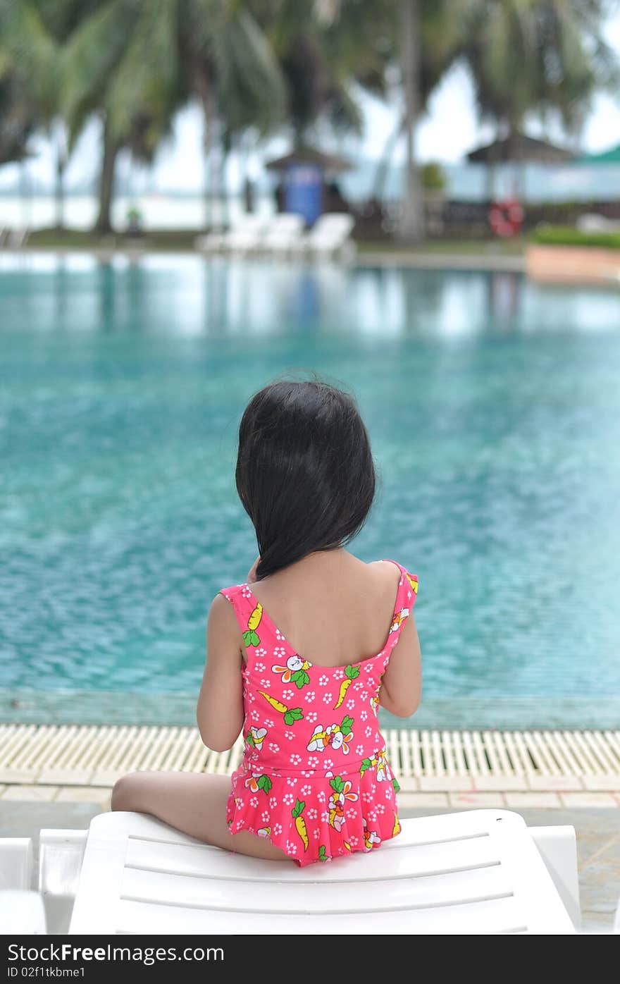 Little girl relaxes by the pool. Little girl relaxes by the pool