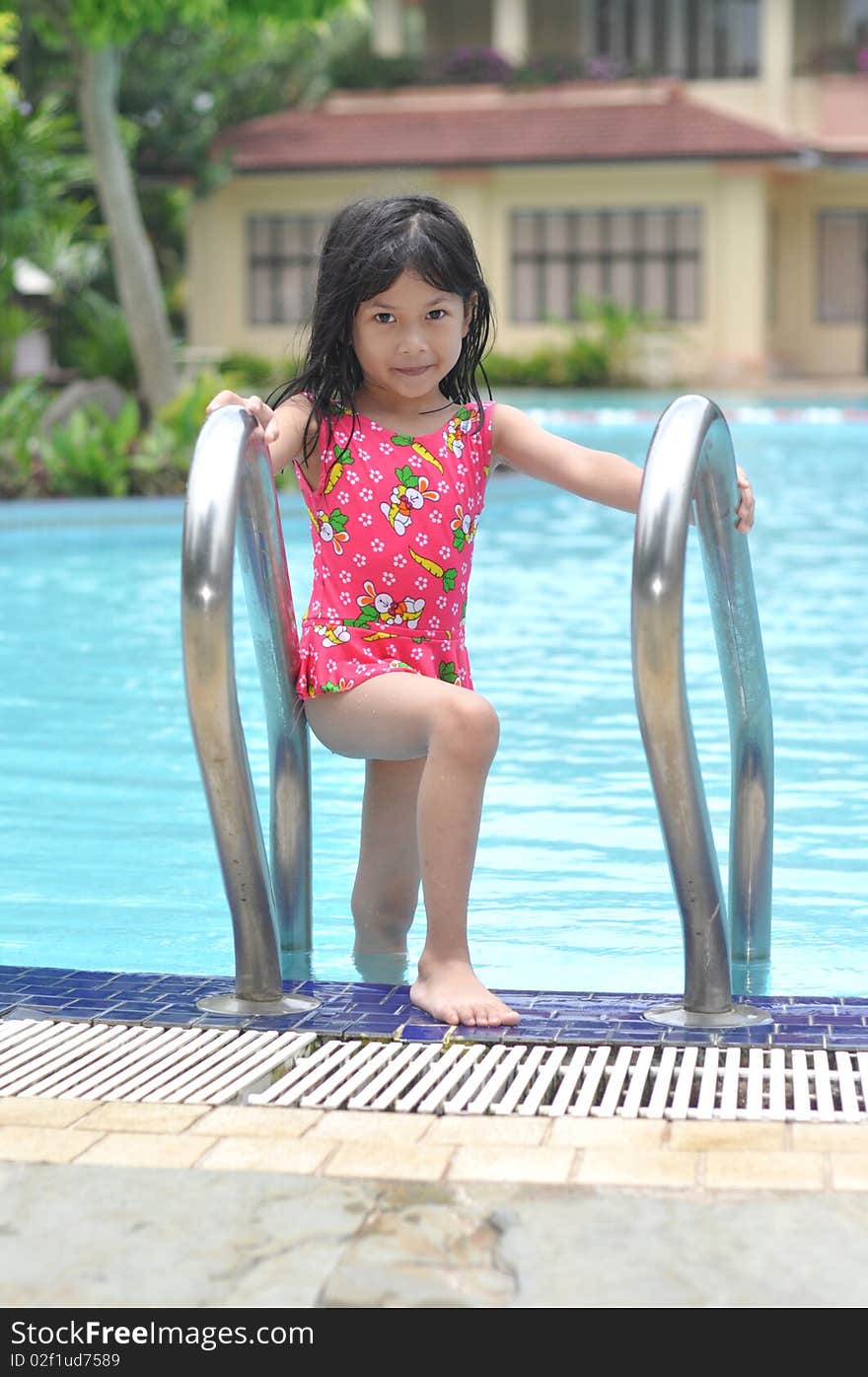 Cute little girl getting out of swimming pool