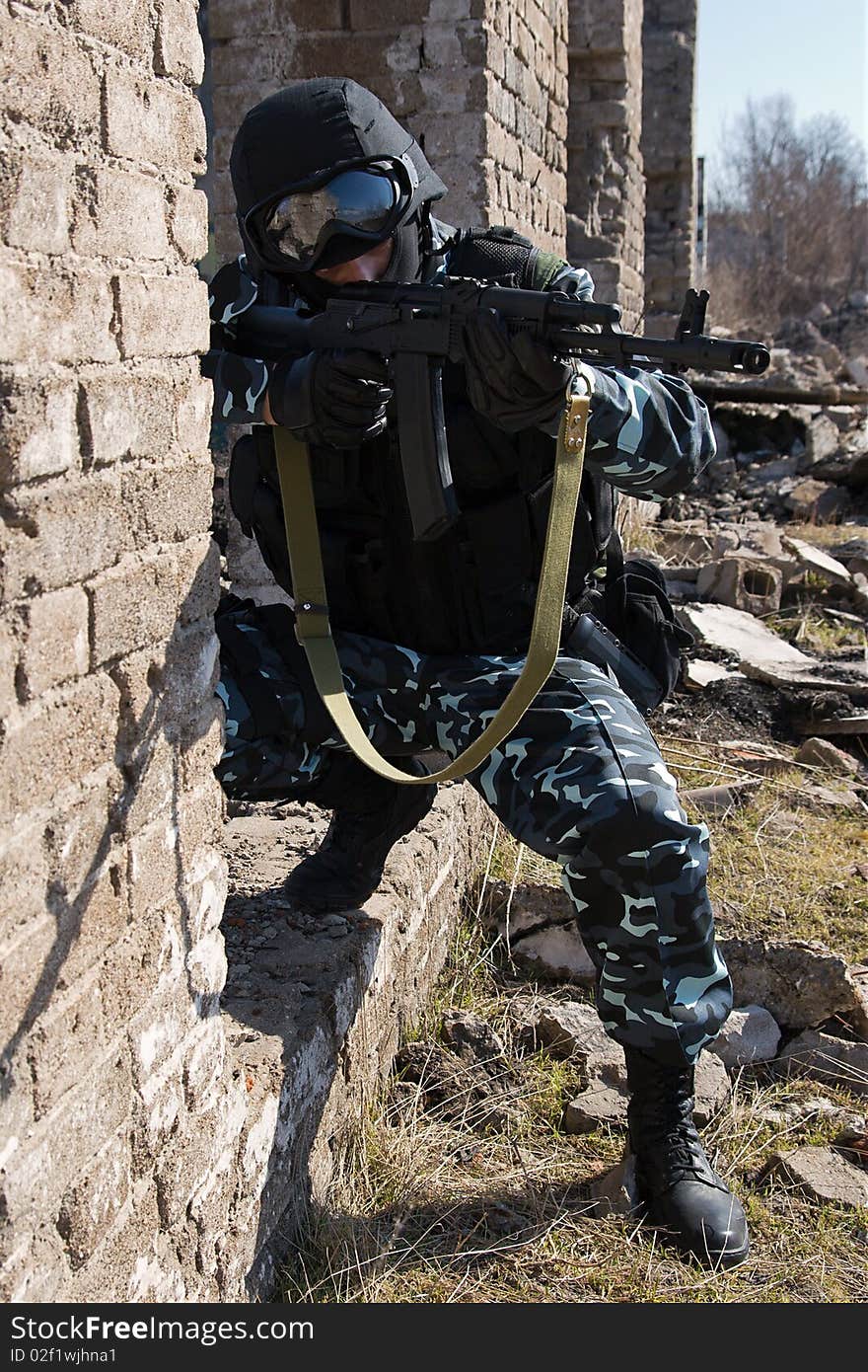 Armed officer in full ammunition targeting with automatic rifle. Armed officer in full ammunition targeting with automatic rifle