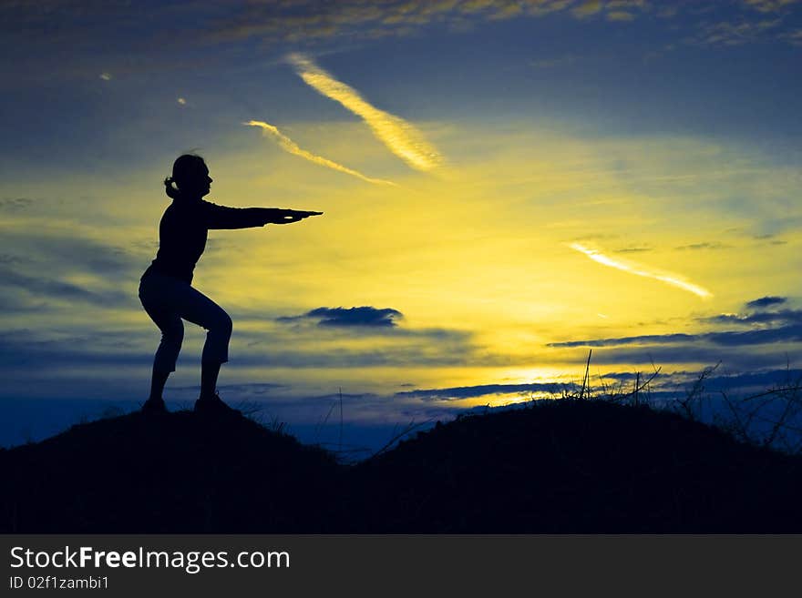 Sporty, slim girl relaxing in the sunset. Sporty, slim girl relaxing in the sunset