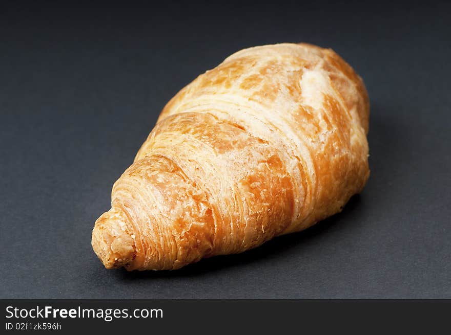 Single fresh croissant, studio shot