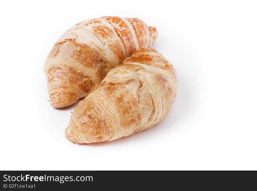 Two fresh croissants on white