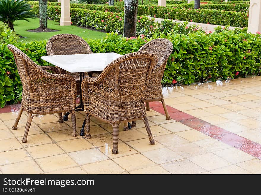 Brown wooden chairs an tables on patio in the morning