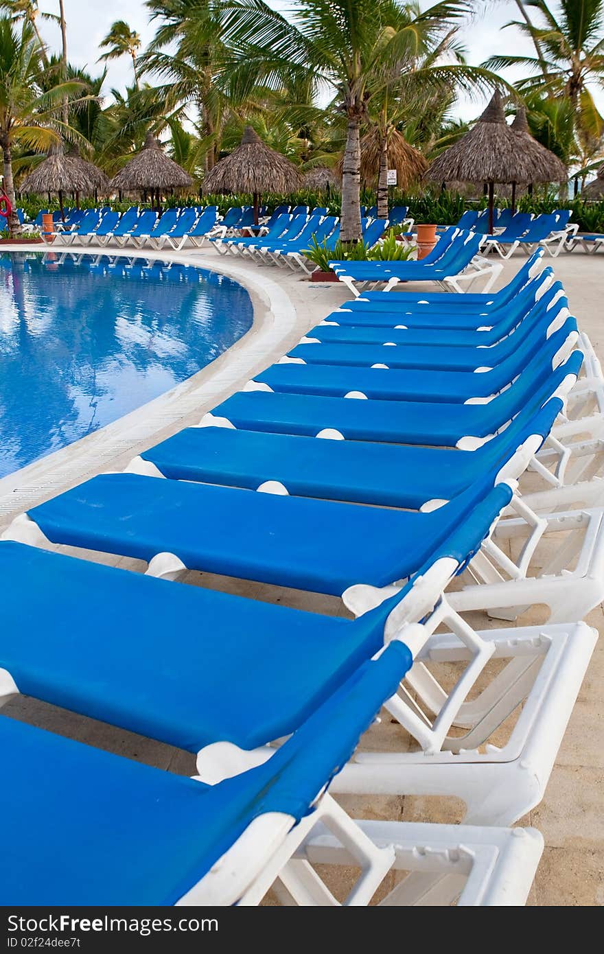 Blue and white plastic lounges near pool