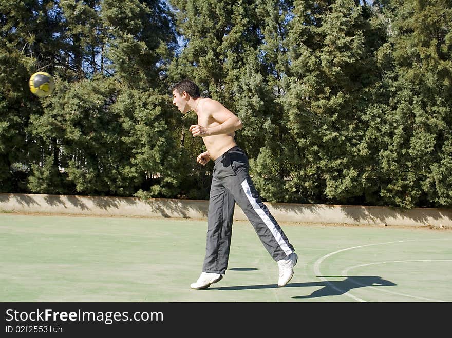 A young man playing football hitting the ball with his head. A young man playing football hitting the ball with his head