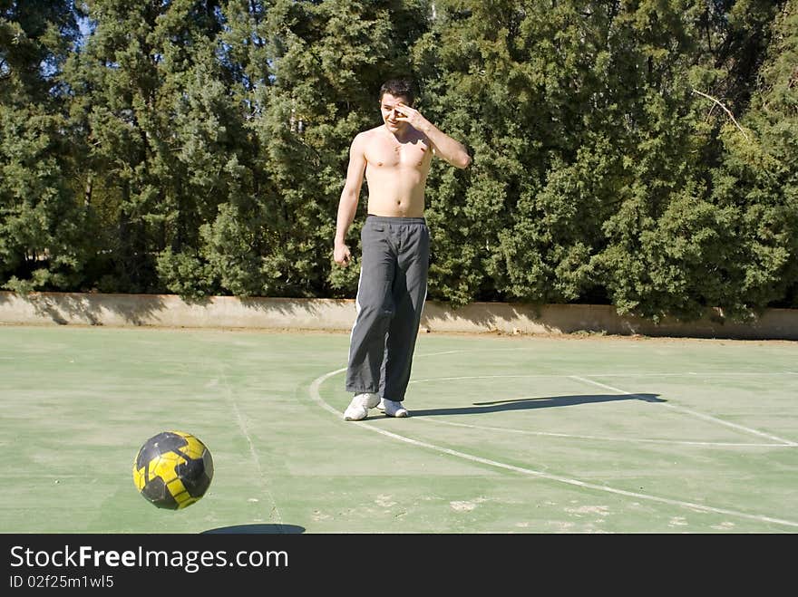 A young man playing football on a sunny warm day. A young man playing football on a sunny warm day