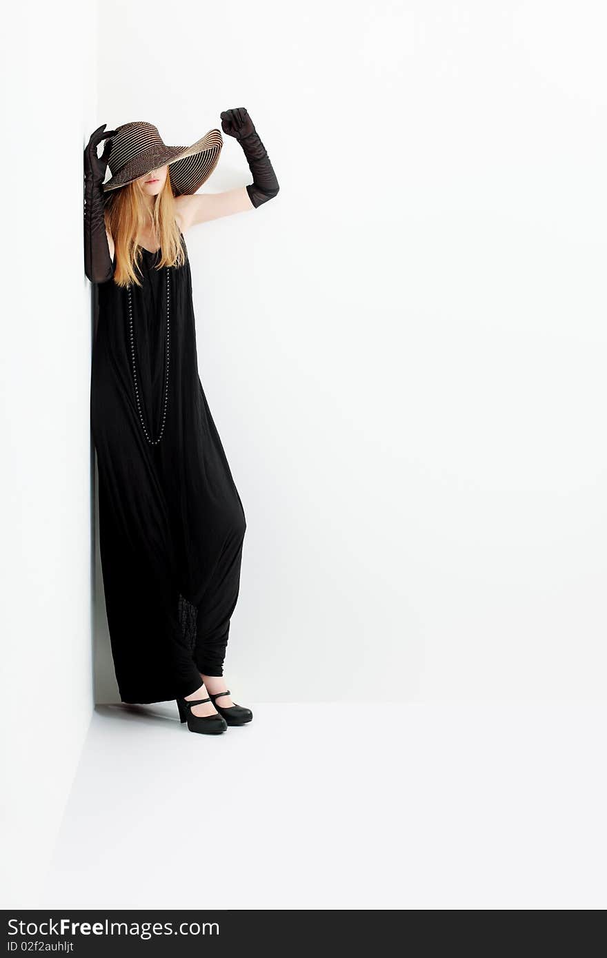 Portrait of a beautiful girl in elegant black dress and a  hat. Portrait of a beautiful girl in elegant black dress and a  hat.