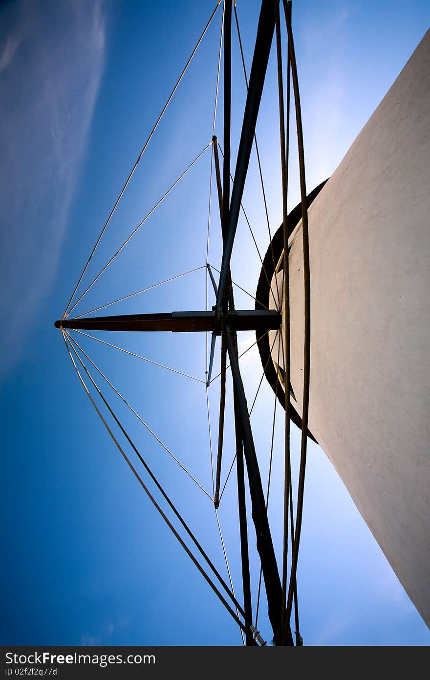 A close up look at a windmill. Looking directly up at the mill with blue skies behind it. A close up look at a windmill. Looking directly up at the mill with blue skies behind it.