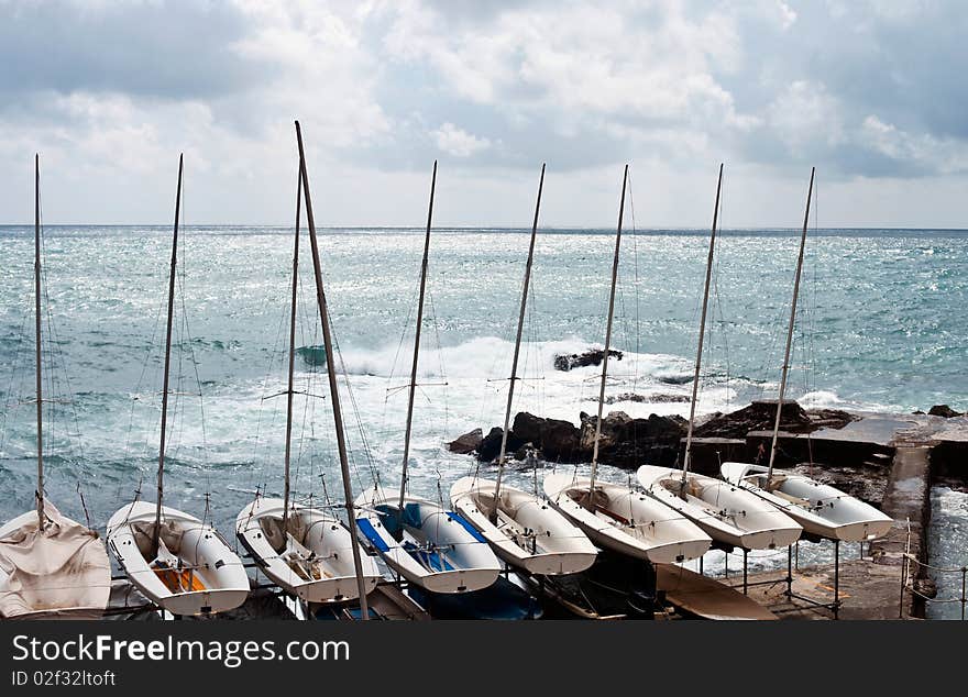 A row of sailboats raised by the sea