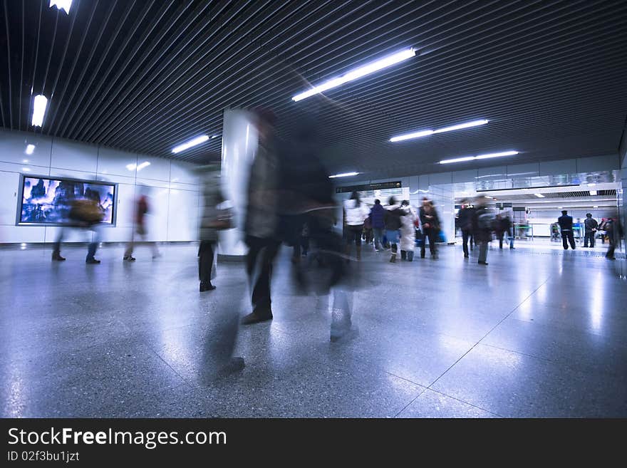 Clean tiled floor, reflection of light on floor and blurred view of people walking. Clean tiled floor, reflection of light on floor and blurred view of people walking