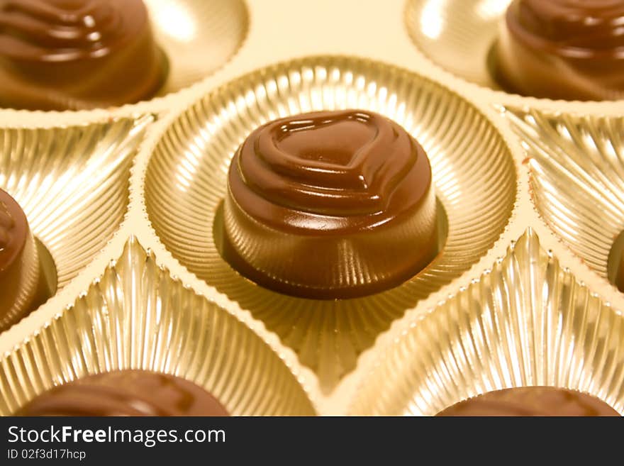 Candy with heart shape on golden plates. Candy with heart shape on golden plates