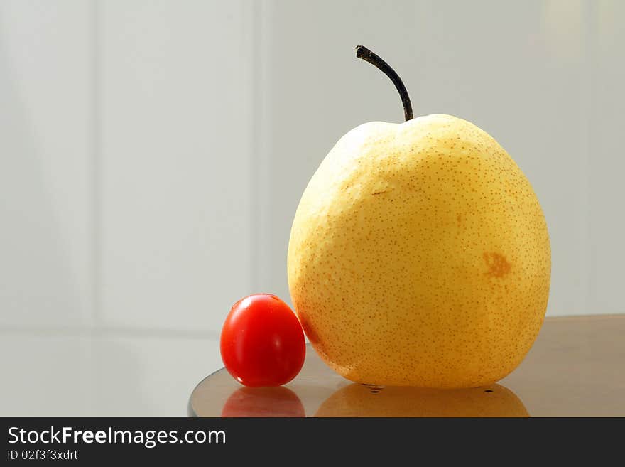 The close-up of pear and small tomato. The close-up of pear and small tomato