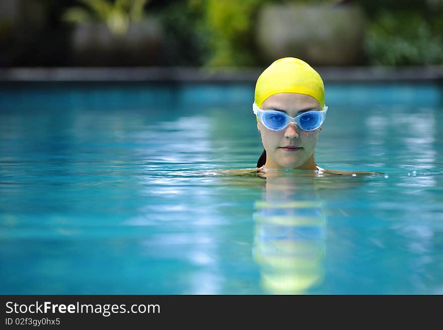 Pretty girl is training in the hotel pool