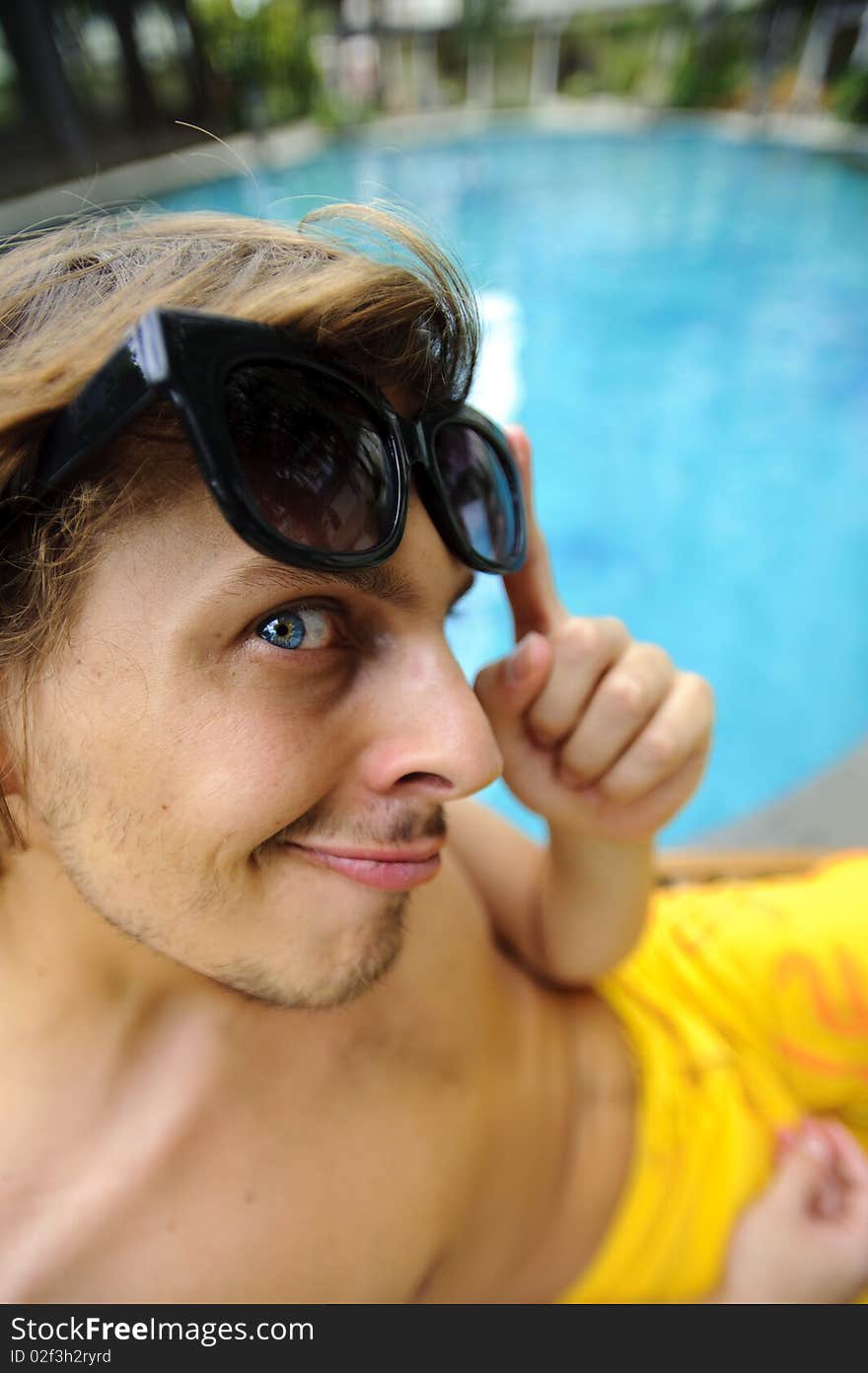 Tanning man looks at camera as he enjoys the hotel resort. Tanning man looks at camera as he enjoys the hotel resort