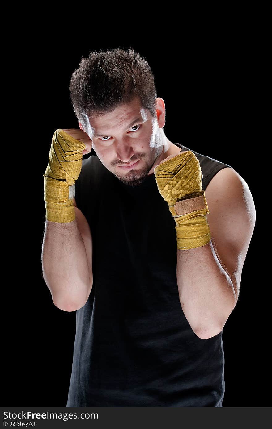 Young man in defensive boxing pose isolated on black. Young man in defensive boxing pose isolated on black