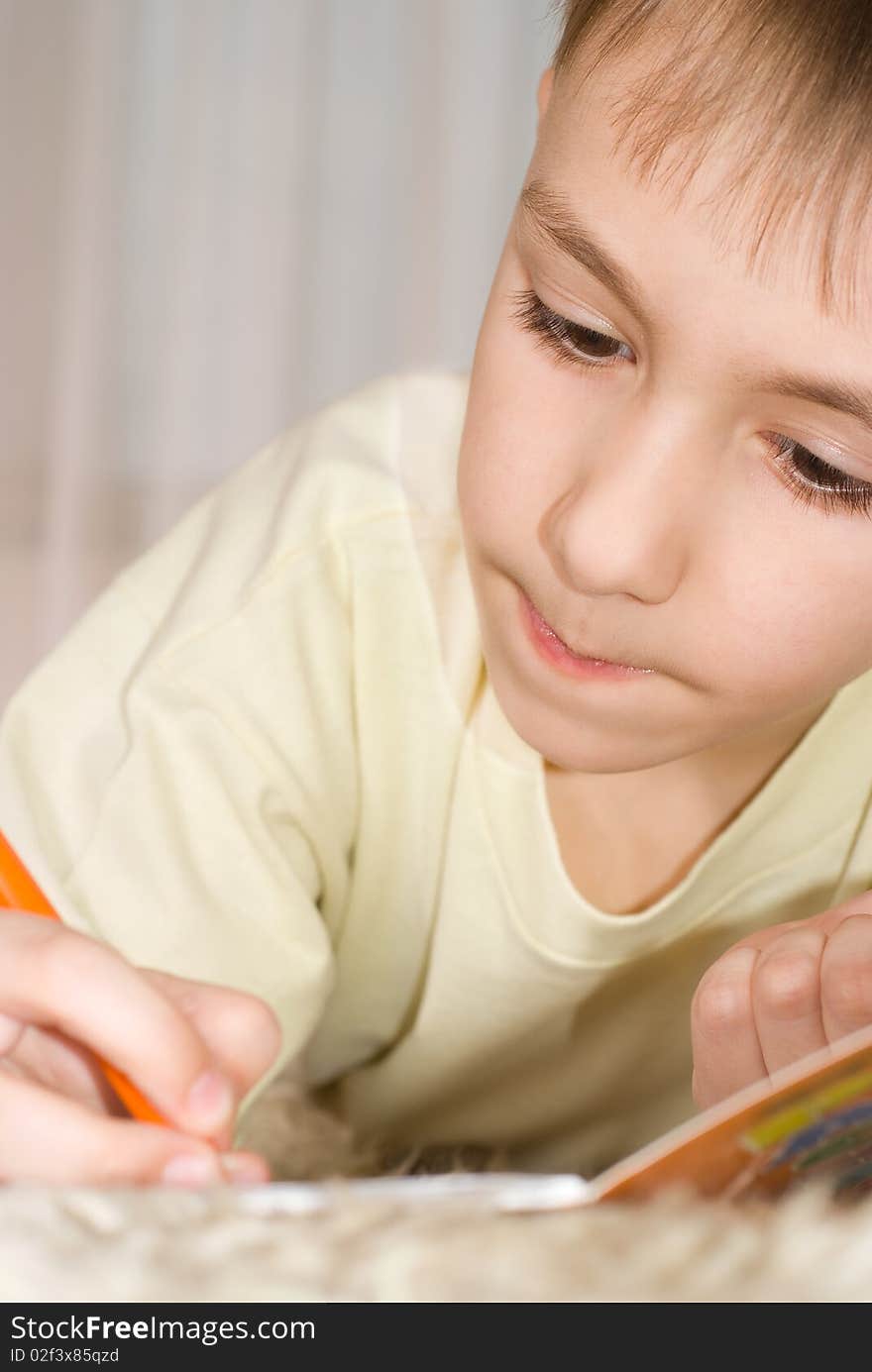 Boy lying on the carpet and drawing a picture. Boy lying on the carpet and drawing a picture