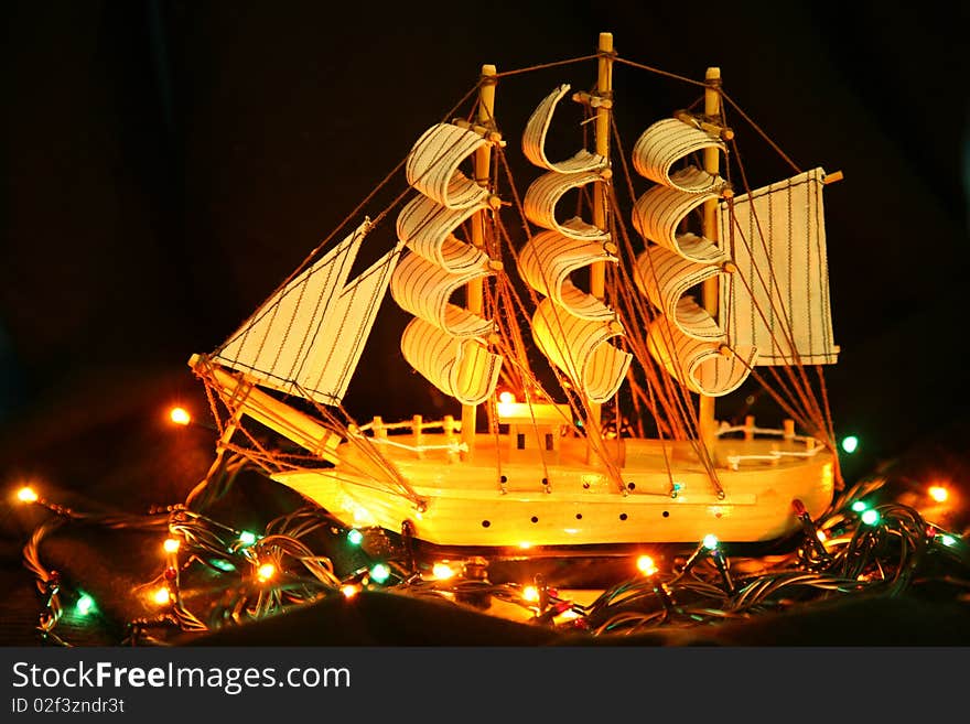 Model yachts on a black background illuminated by small lamps. Model yachts on a black background illuminated by small lamps