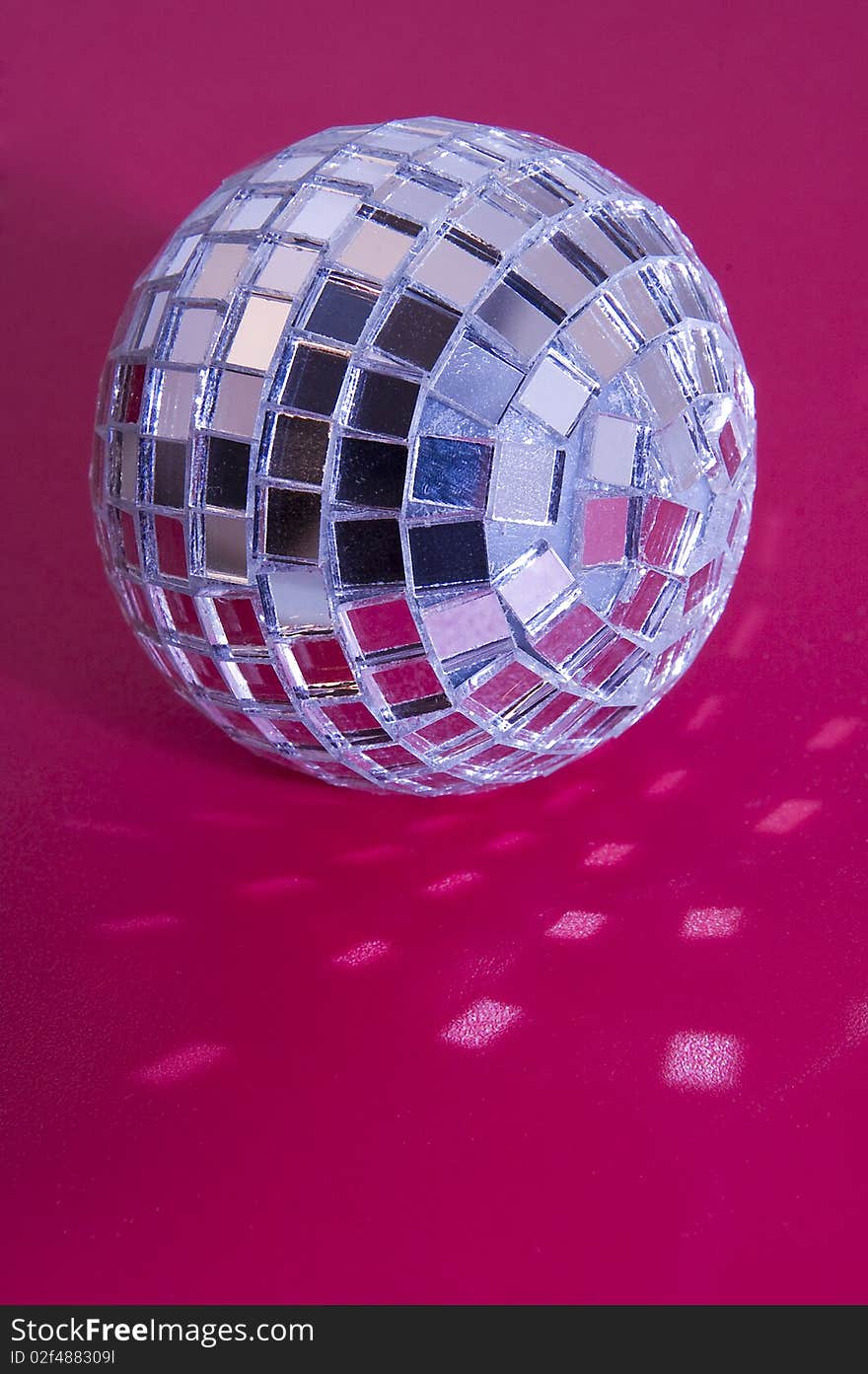 Music disco ball on pink background, light reflections