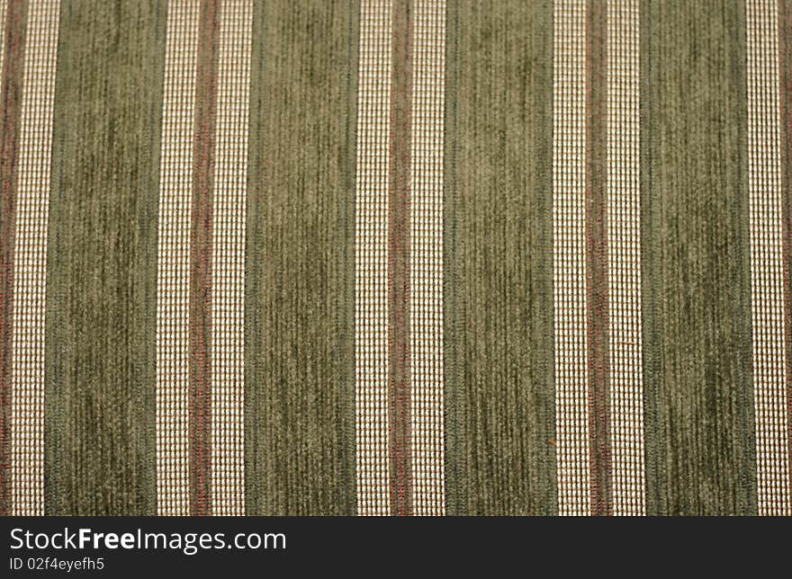 A closeup of green and gold striped upholstery fabric. A closeup of green and gold striped upholstery fabric.