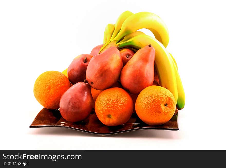 Fruit, pears, oranges and bananas on a plate photographed in front of white background. Fruit, pears, oranges and bananas on a plate photographed in front of white background