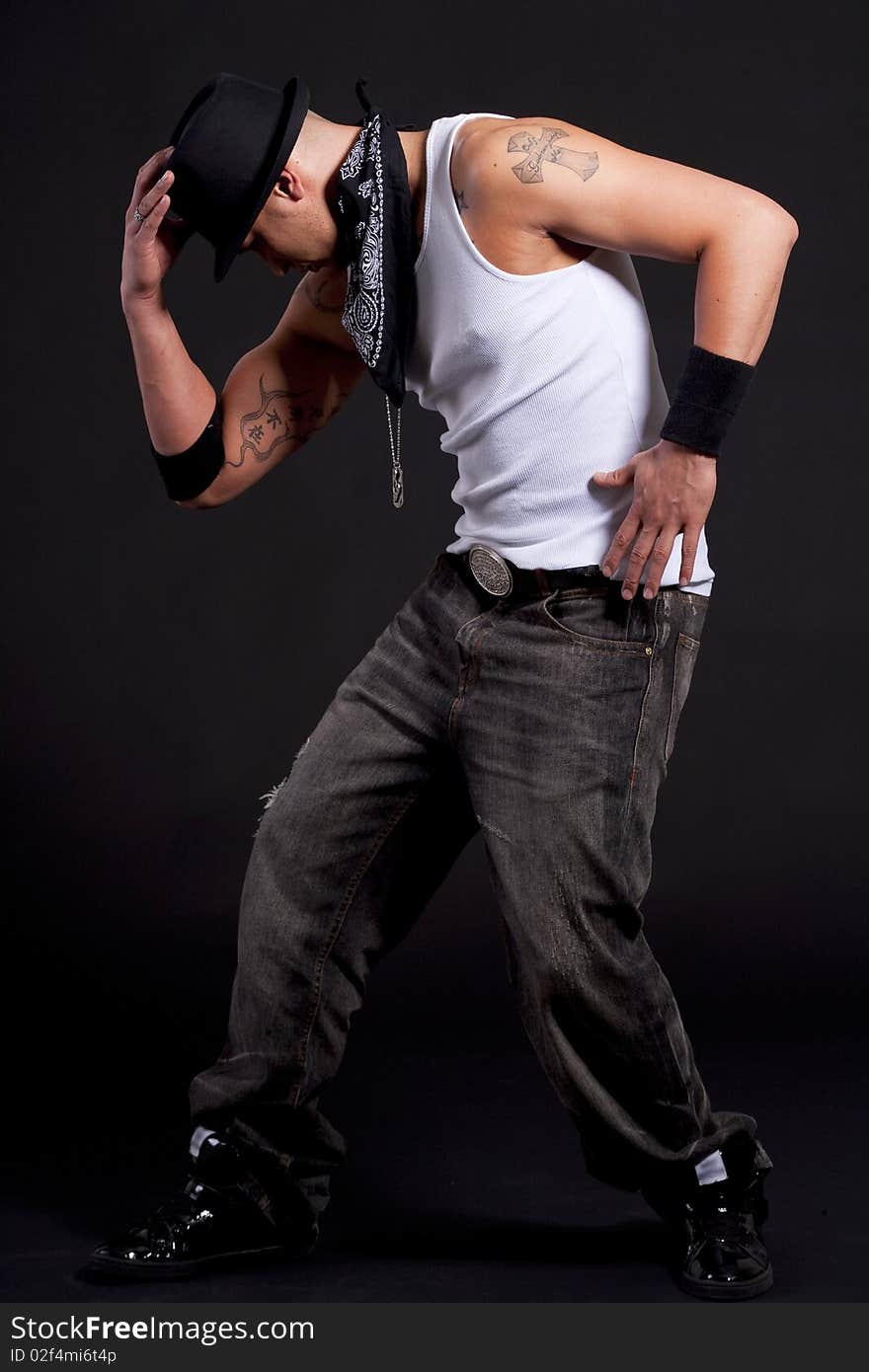 Young stylish asian dancer in front of black background moving to hip jop music. Young stylish asian dancer in front of black background moving to hip jop music.