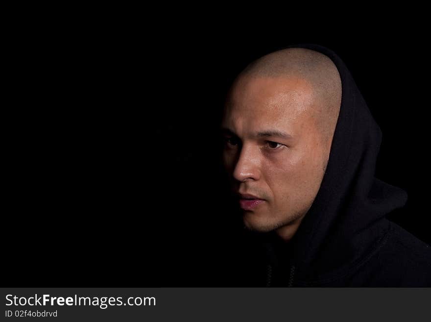 Stylish young man with hoddie over a black background.