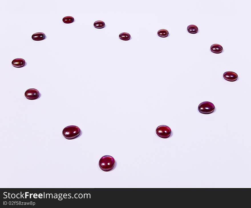 Lovesymbol, heart out of red stones on white underground