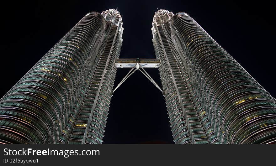 Twin skyscrapers in the night. Low angle view.