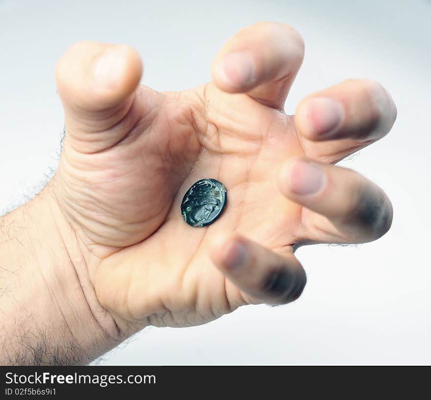 Old roman coin in threaten human hand