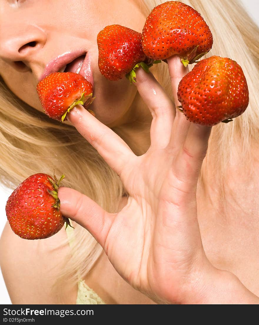 Sweet caucasian girl eating strawberries picked on fingertips