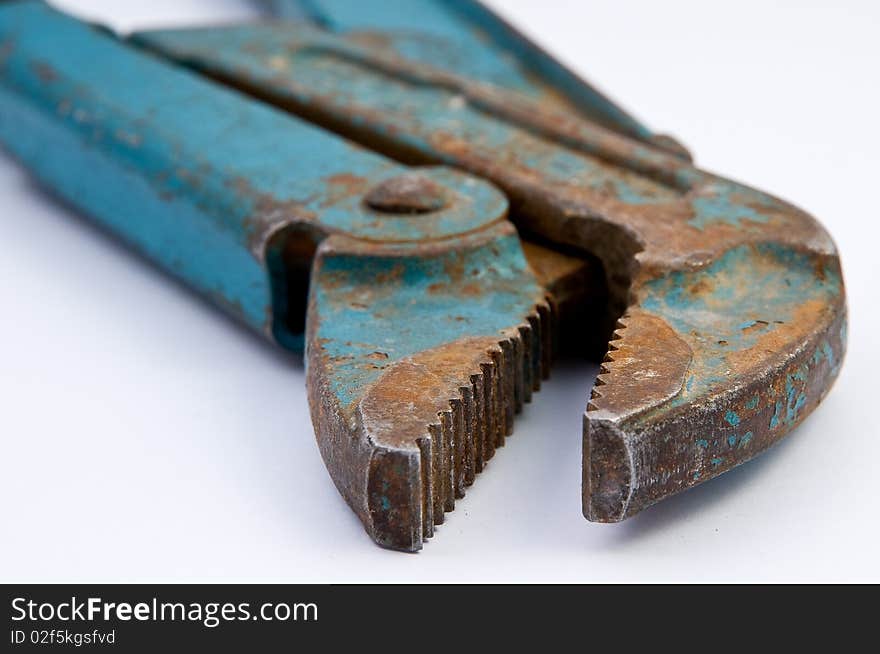 Old green and rusty pipe tongs on white underground